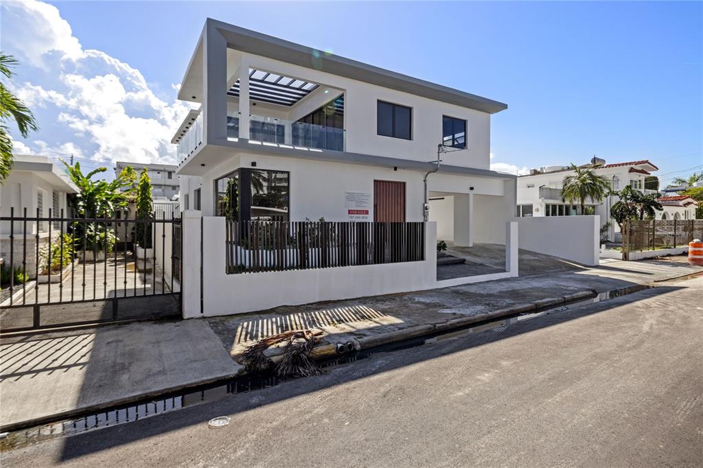 A modern two-story white house with a balcony, glass railings, and a gated driveway — 2058 CACIQUE, SAN JUAN, PR