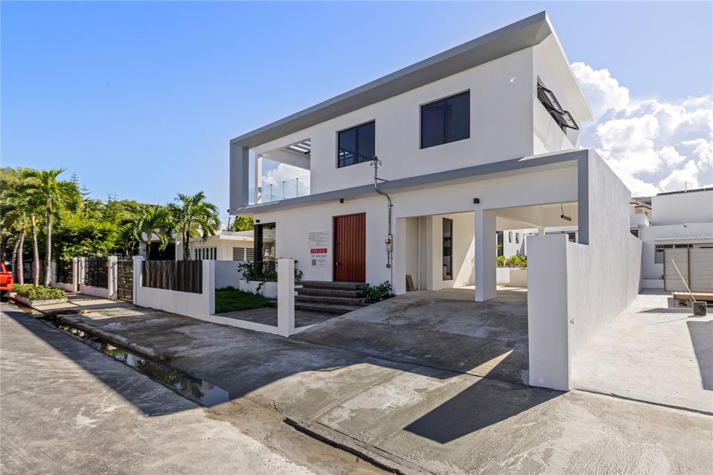 A modern two-story white house with a carport, flat roof, and a wooden front door — 2058 CACIQUE, SAN JUAN, PR