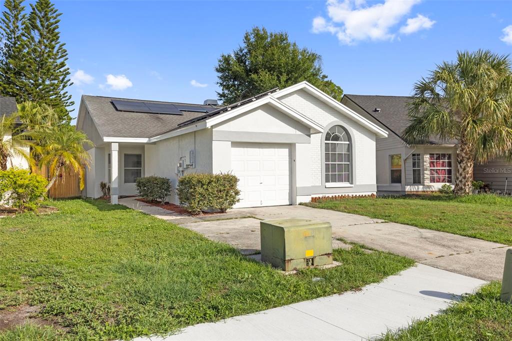 A single-story house with a white exterior, a garage, and solar panels on the roof — 11651 SUNSHINE POND ROAD, TAMPA, FL