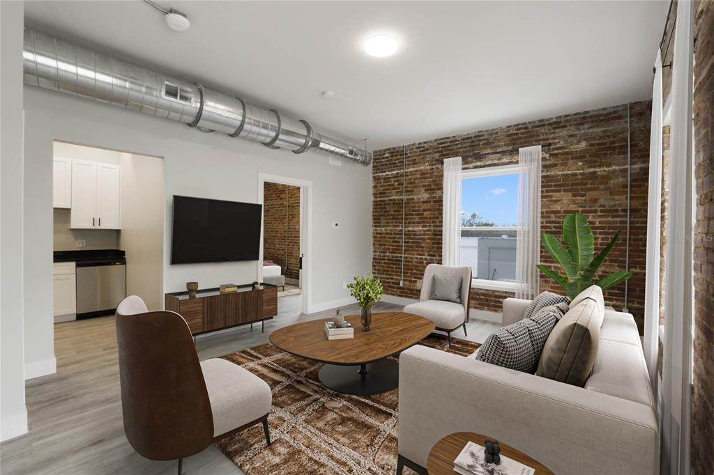 A living room features exposed brick walls, industrial ductwork, and a view into a kitchen — 792 W MONTROSE STREET UNIT 205, CLERMONT, FL