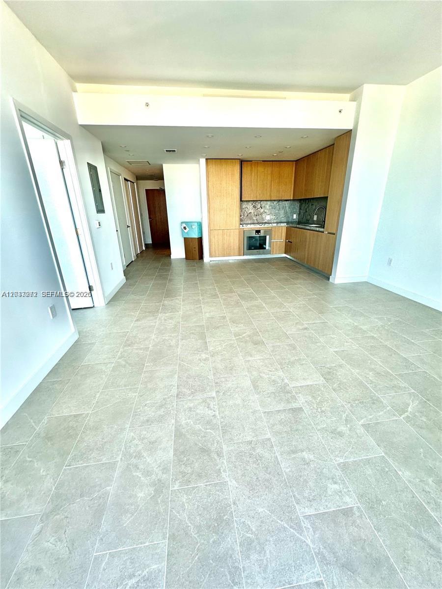 This open-concept living area features light gray tile flooring and a modern wood-toned kitchen — 500 Alton Rd # 2108, Miami Beach FL 33139, MIAMI BEACH, FL