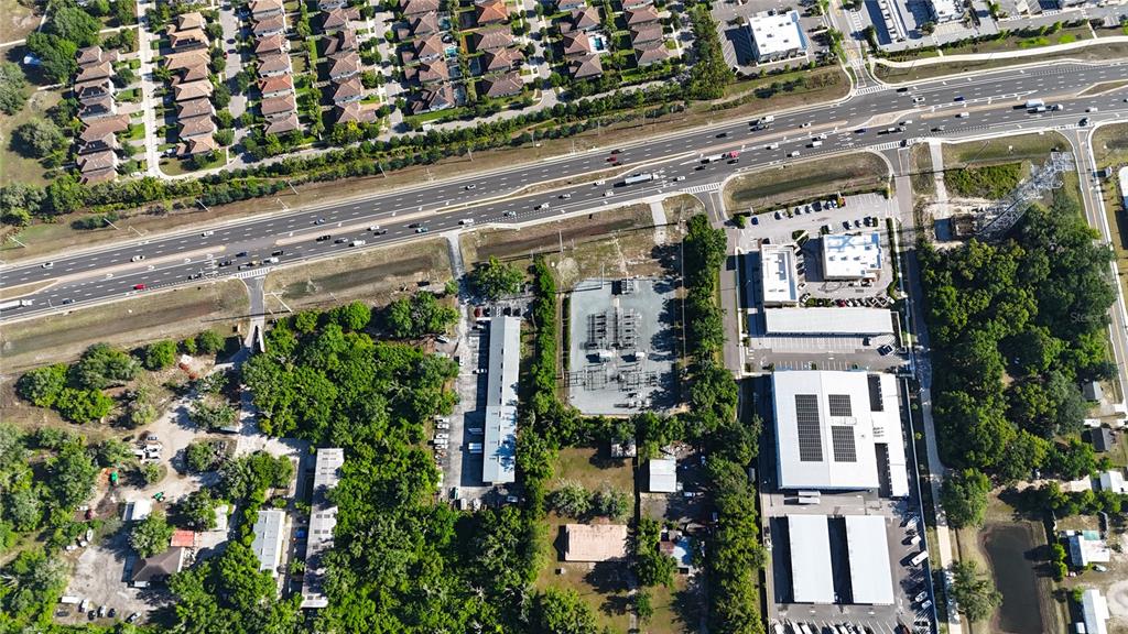 This aerial view shows a commercial property with a substation, parking lots, and nearby roads — 13203 BLISSFIELD, ODESSA, FL