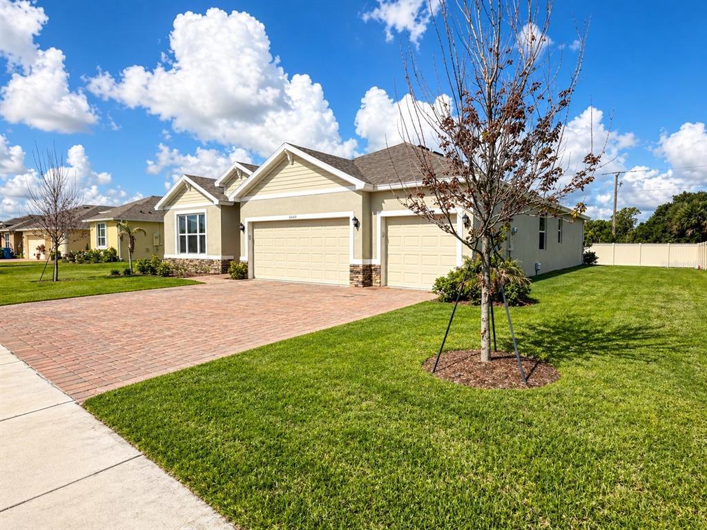 A single-story house with a brick paver driveway, two-car garage, and a manicured lawn — 6860 CAMEO DR, GRANT VALKARIA, FL