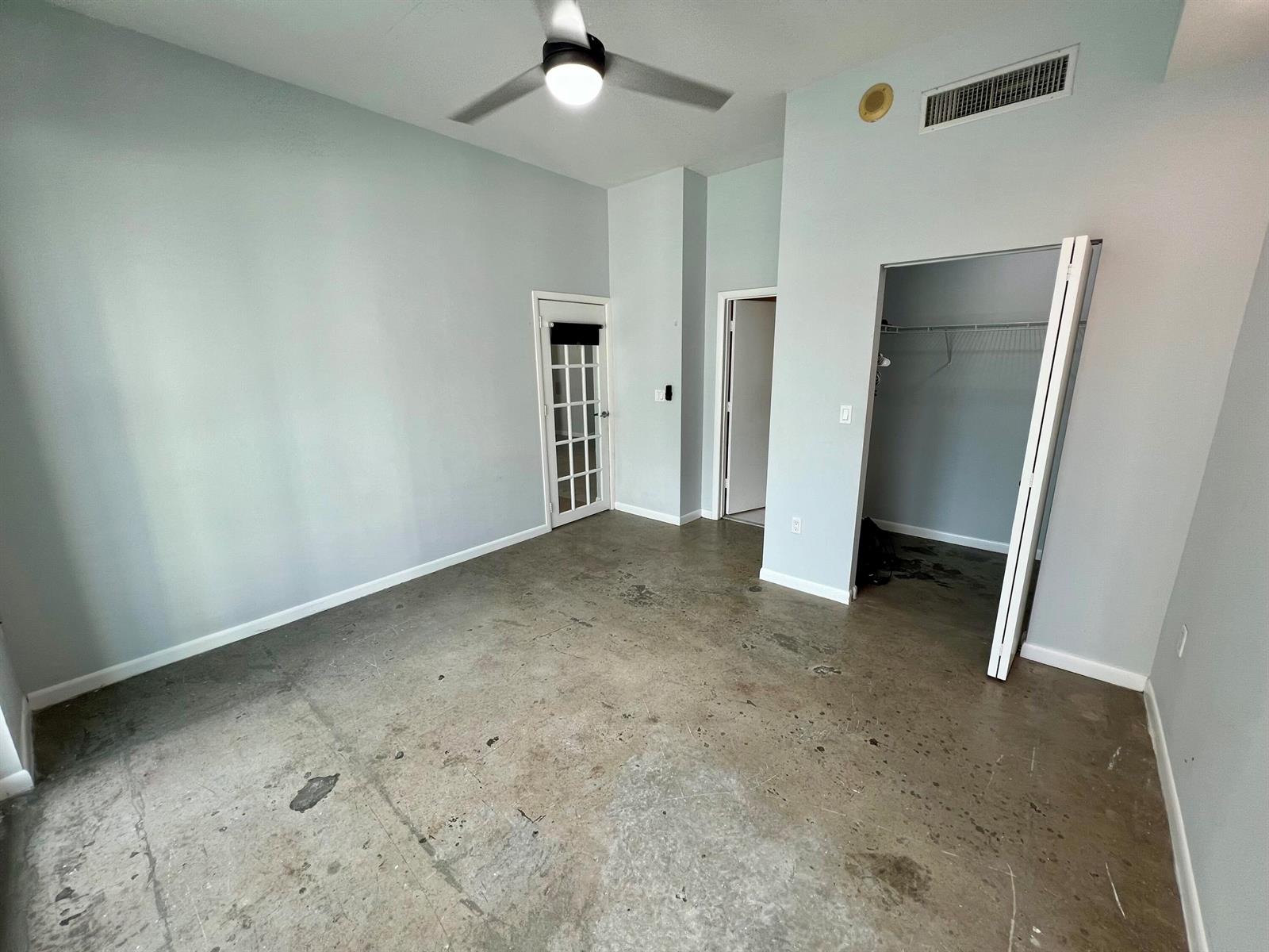 An empty room with light blue walls, a ceiling fan, and a stained concrete floor — 133 NE 2nd Avenue # 1006, Miami FL 33132, MIAMI, FL