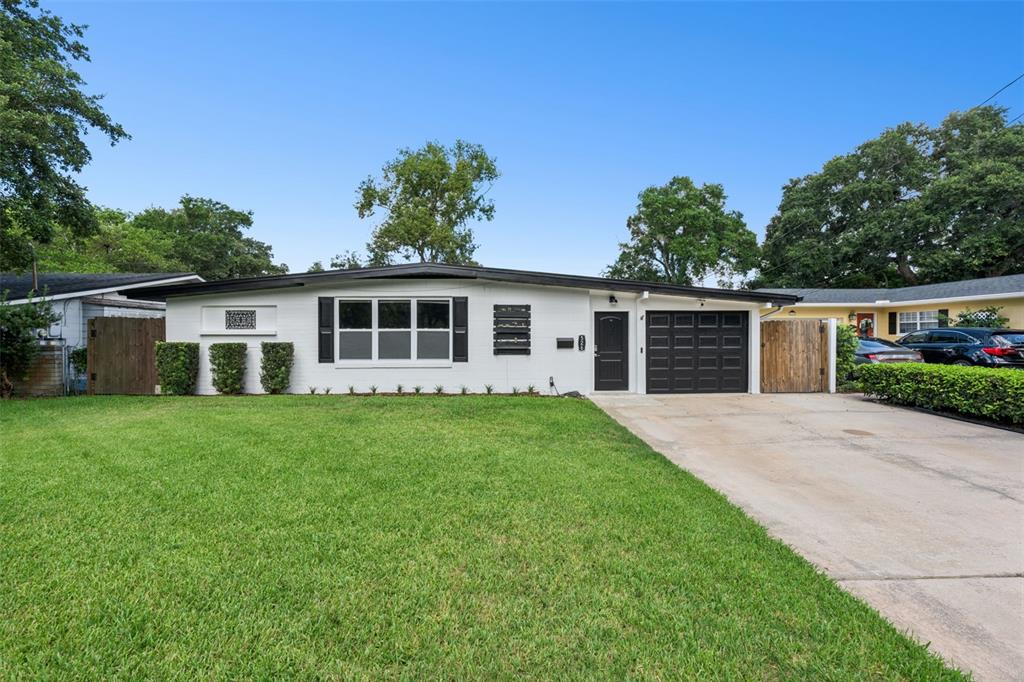 A single-story white brick house with a dark garage door and a front lawn — 526 N HAMPTON AVENUE, ORLANDO, FL