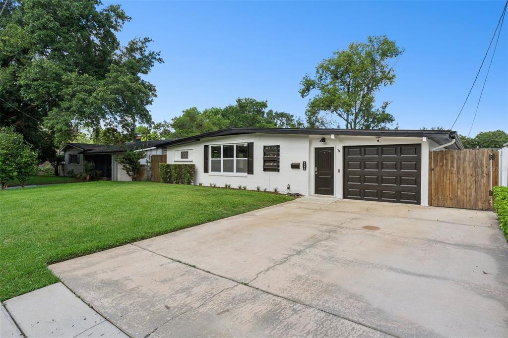 A white single-story house with a dark garage door and a concrete driveway — 526 N HAMPTON AVENUE, ORLANDO, FL