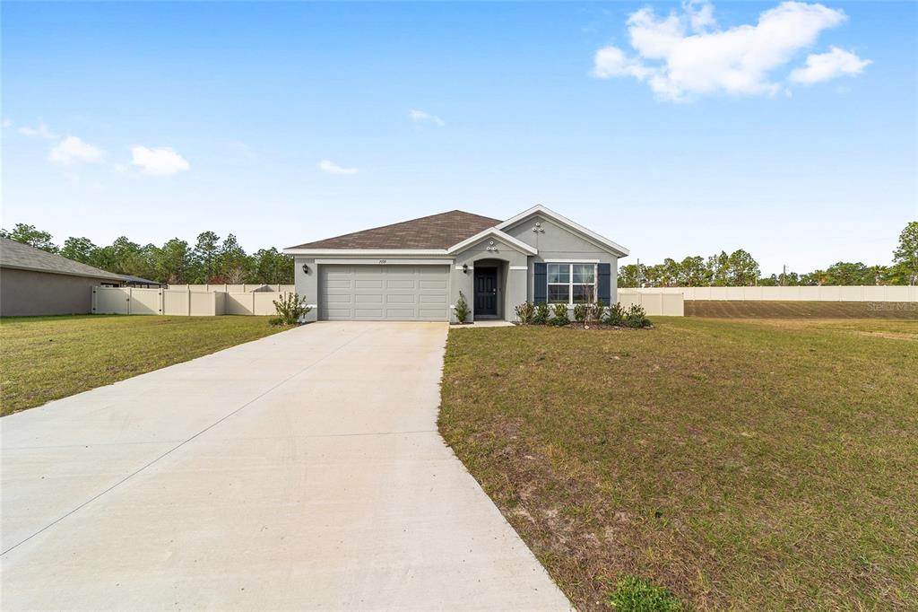 A single-story gray house with a two-car garage and a concrete driveway — 7199 SW 135TH PLACE, OCALA, FL