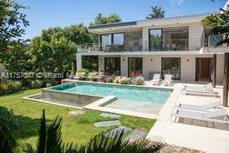 A two-story modern house with a swimming pool and patio area in a grassy backyard — 41 route des breguieres, CT 06110, CT