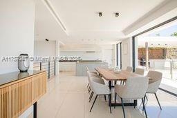 A modern dining area with a wooden table, light-colored chairs, and large glass sliding doors — 41 route des breguieres, CT 06110, CT