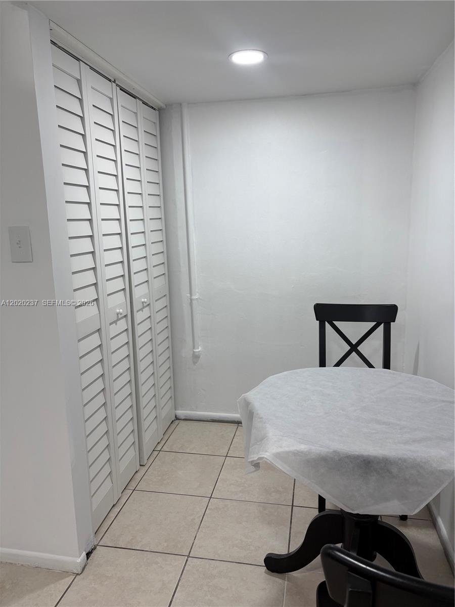 A small room features white louvered closet doors, tiled flooring, and a small dining table — 15844 SW 82nd St # b, Miami FL 33193, MIAMI, FL