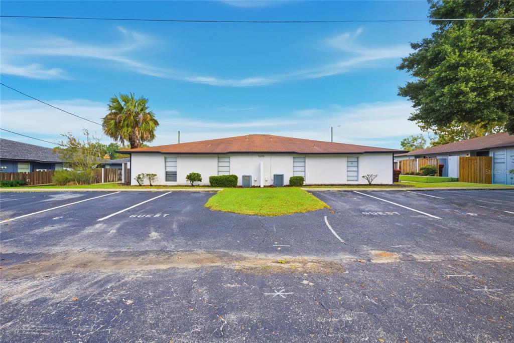 A single-story white apartment building with a brown roof sits behind a paved parking lot — 5395 SE 30TH PLACE ALL UNITS, OCALA, FL