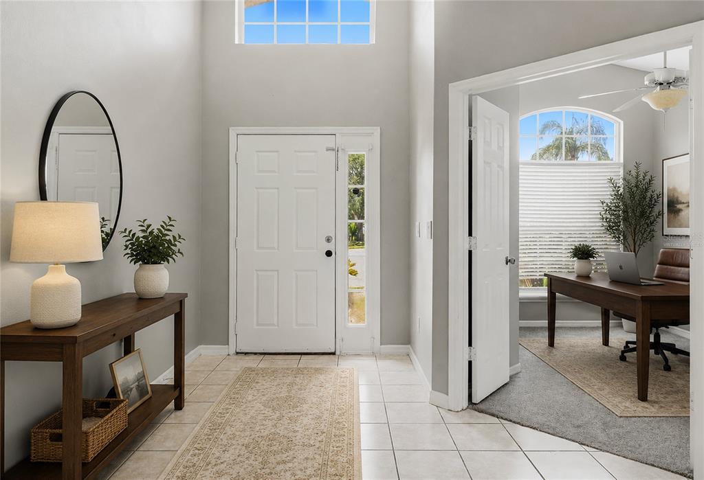 A bright entryway features tile flooring, a console table, and a doorway leading to an office — 2572 ACUNA COURT, LAKE MARY, FL