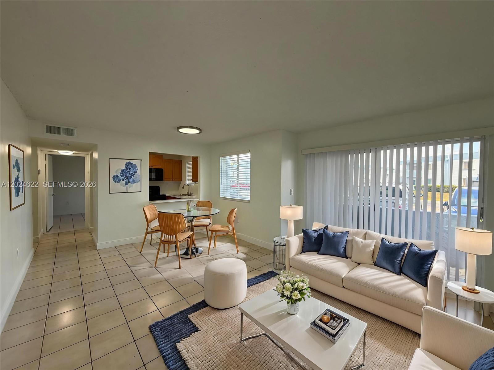 A living room and dining area feature tile floors, a white sofa, and sliding doors — 6207 SW 131st Ct # 101, Miami FL 33183, MIAMI, FL