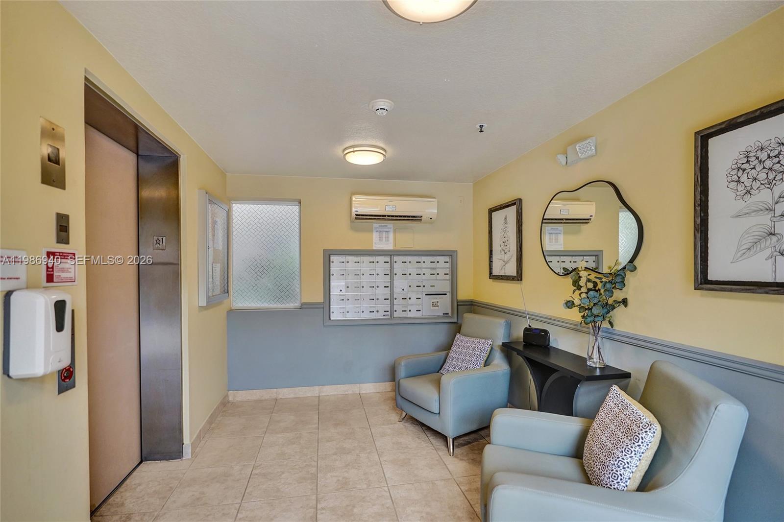 The exterior of a multi-story tan apartment building features a covered entrance and palm trees — 12547 Imperial Isle Dr # 206, Boynton Beach FL 33437, BOYNTON BEACH, FL
