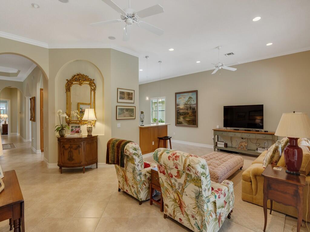 A living room features tile floors, floral armchairs, a television console, and a built-in bar — 1225 Riverwind Circle, Vero Beach FL 32967, VERO BEACH, FL