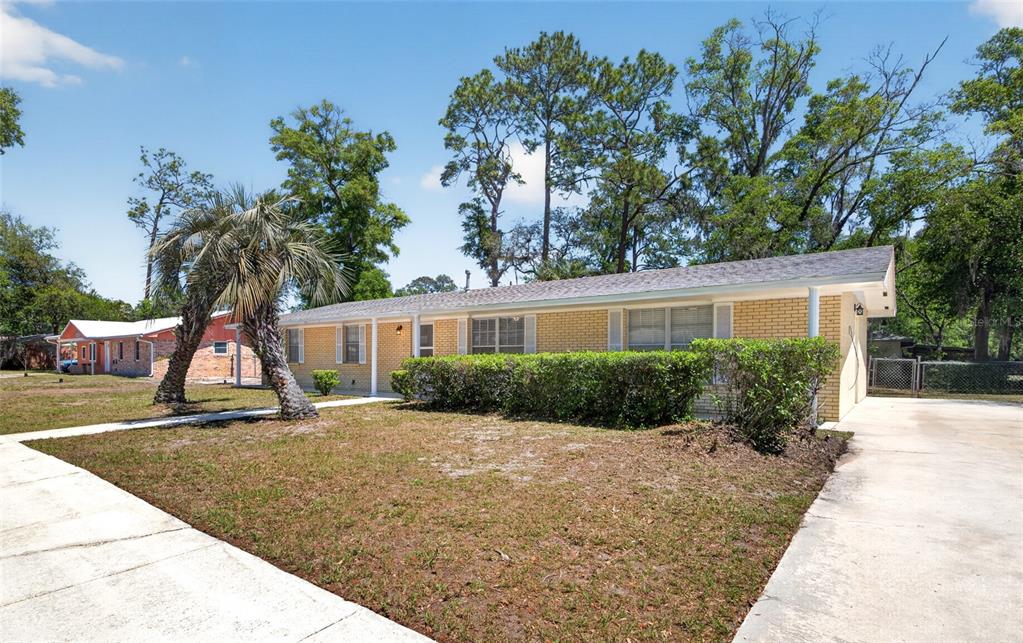 A single-story yellow brick house with a palm tree and a concrete driveway — 3907 NW 21ST STREET, GAINESVILLE, FL