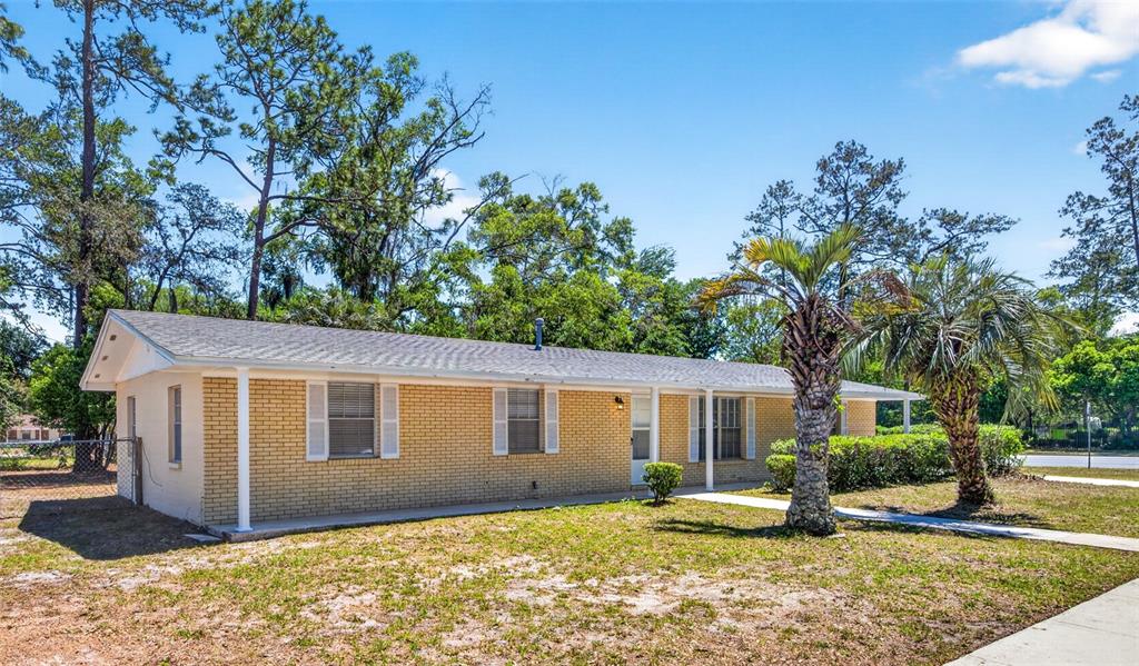 A single-story brick house with a covered porch and palm trees in the front yard — 3907 NW 21ST STREET, GAINESVILLE, FL