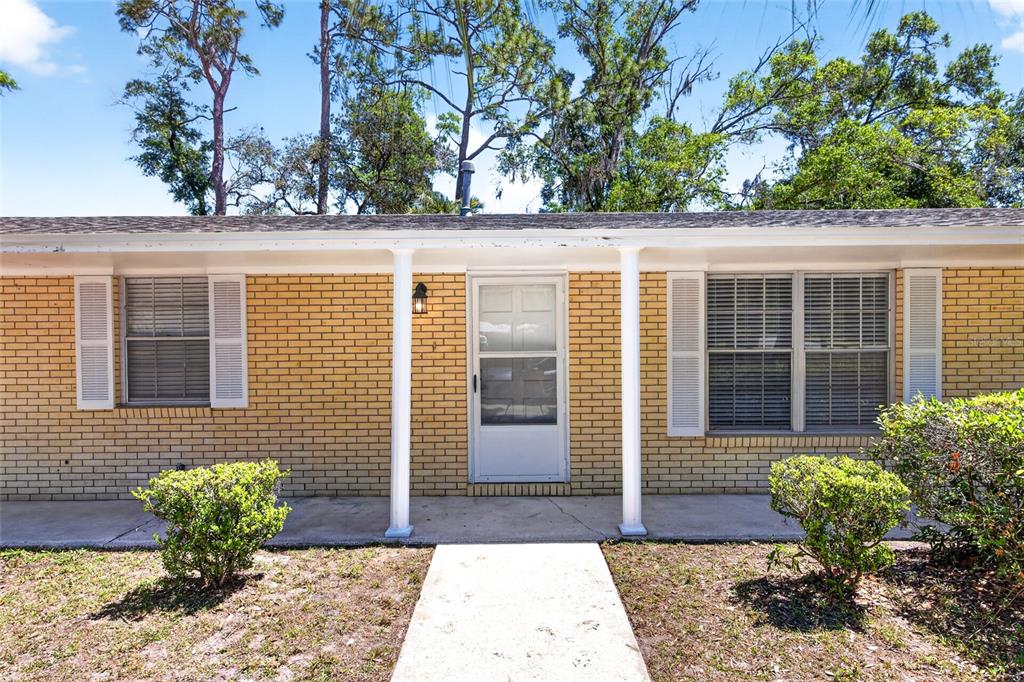 A single-story brick house features a central front door, two windows with shutters, and columns — 3907 NW 21ST STREET, GAINESVILLE, FL