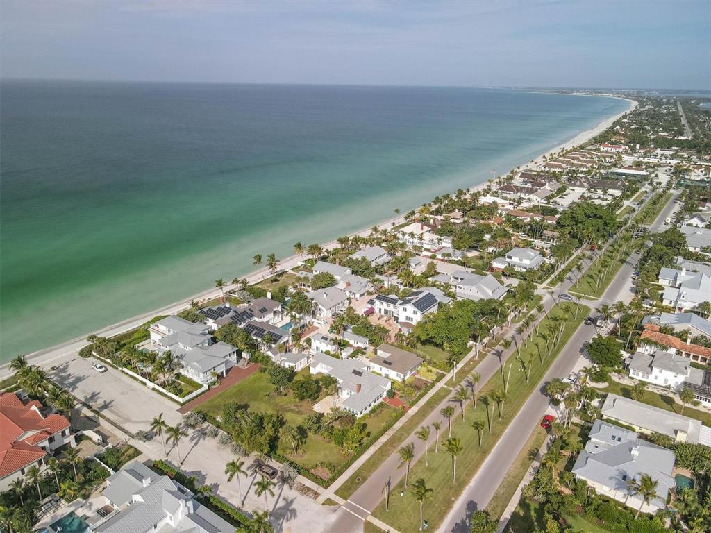 An aerial view shows coastal homes along a sandy beach and a palm-lined road — 231 GILCHRIST AVENUE, BOCA GRANDE, FL