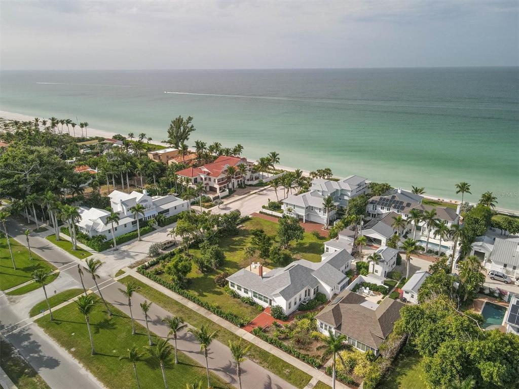 An aerial view shows several coastal homes with palm trees near a sandy beach and ocean — 231 GILCHRIST AVENUE, BOCA GRANDE, FL