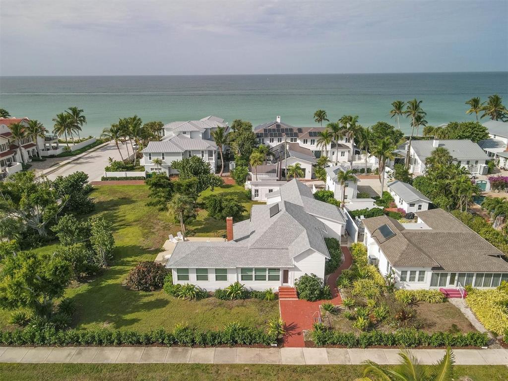 An aerial view shows a white house with a gray roof near the ocean — 231 GILCHRIST AVENUE, BOCA GRANDE, FL