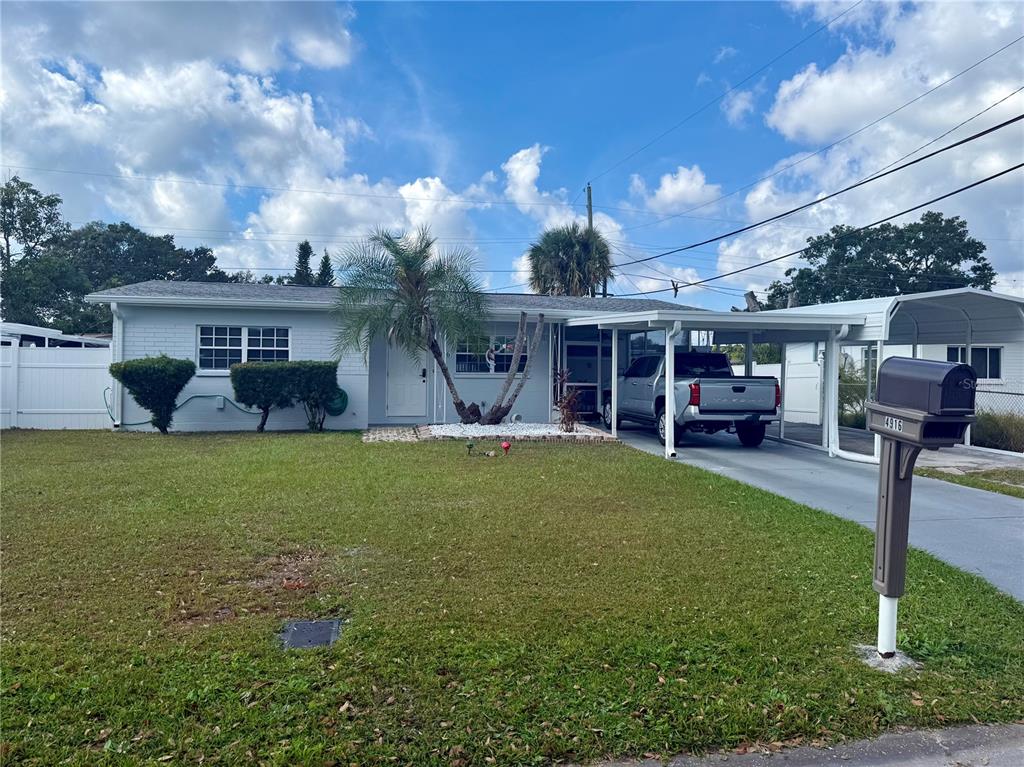 A single-story house with a light-colored exterior, a carport, and a front lawn — 4916 ELDORADO DRIVE, TAMPA, FL