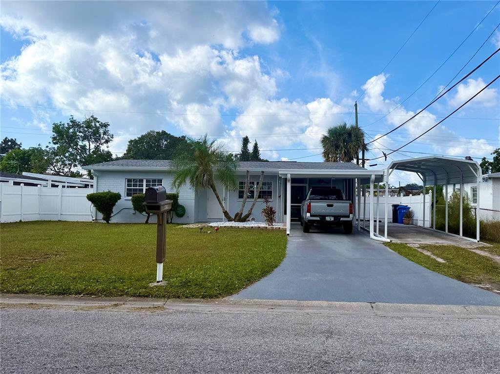 A single-story house with a white brick exterior, a carport, and a front lawn — 4916 ELDORADO DRIVE, TAMPA, FL