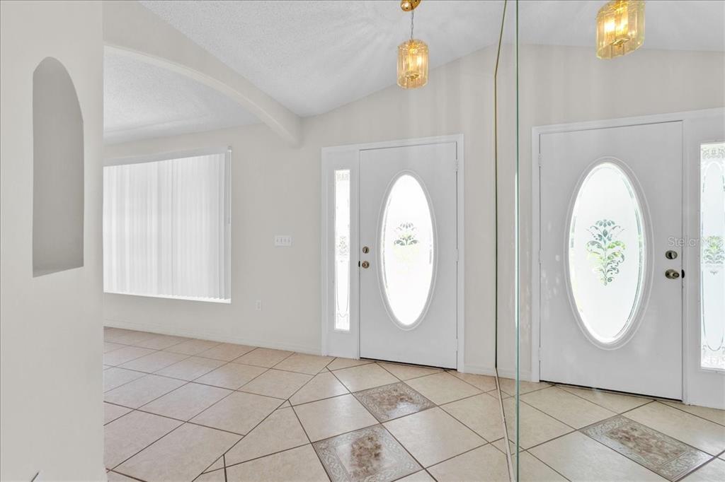 An entryway features tiled floors, a double front door with oval glass, and hanging lights — 112 AZALEA DRIVE, DAVENPORT, FL