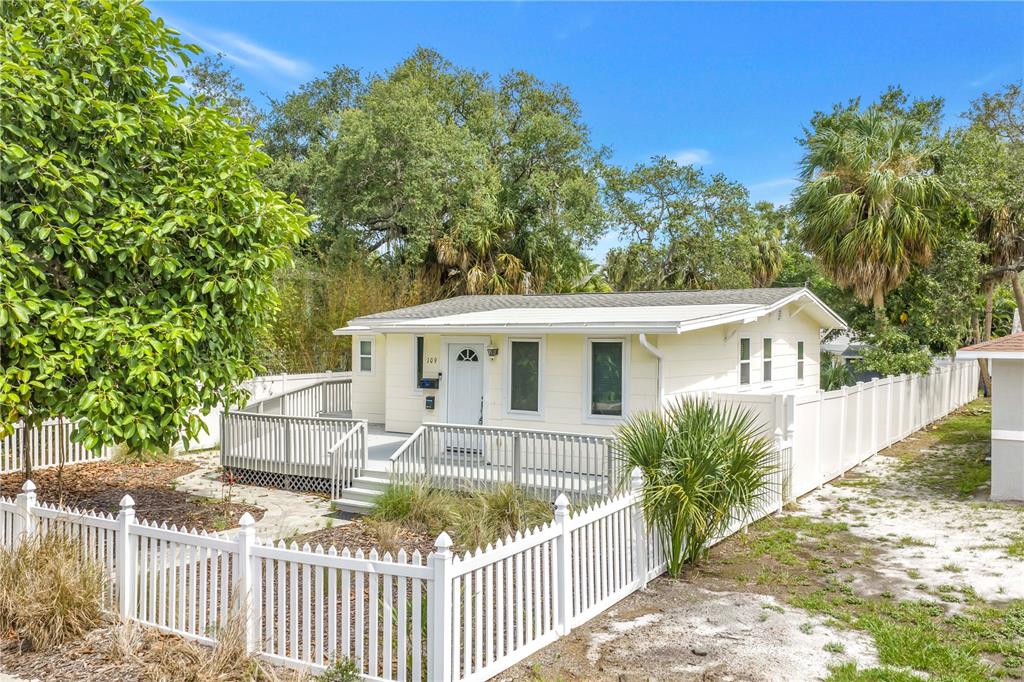 A light yellow single-story house features a white front deck and a white picket fence — 109 20TH AVENUE S, ST PETERSBURG, FL