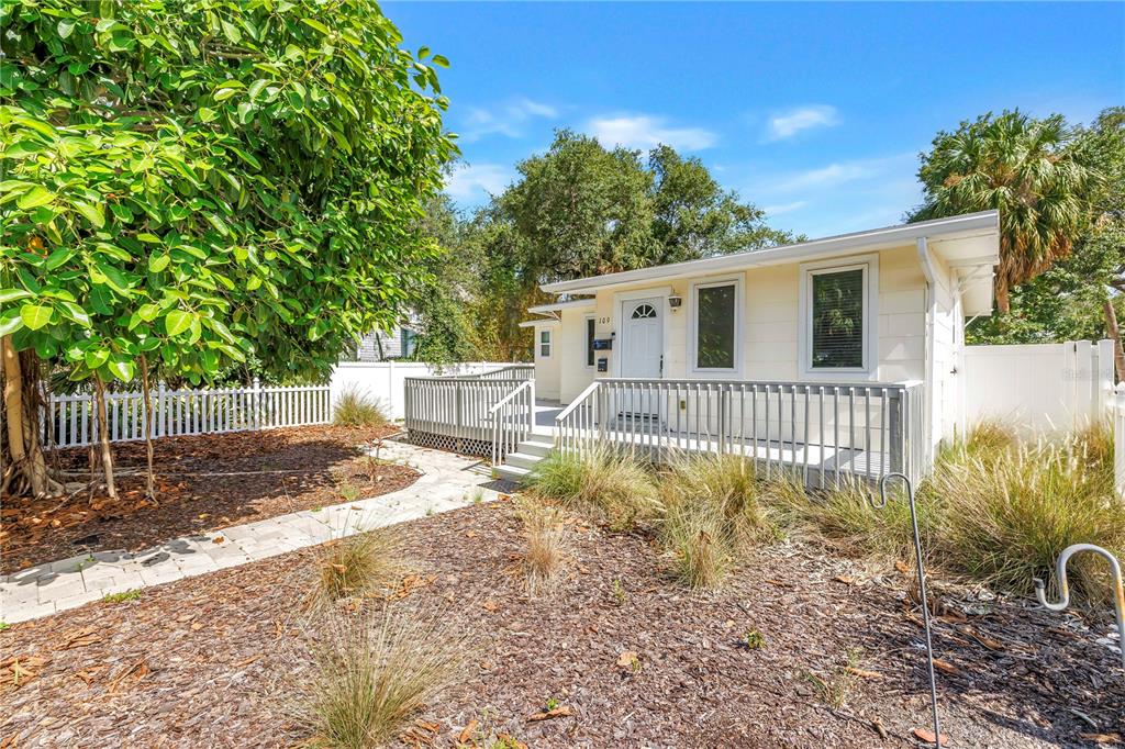 A light yellow house with a white deck and a white picket fence — 109 20TH AVENUE S, ST PETERSBURG, FL