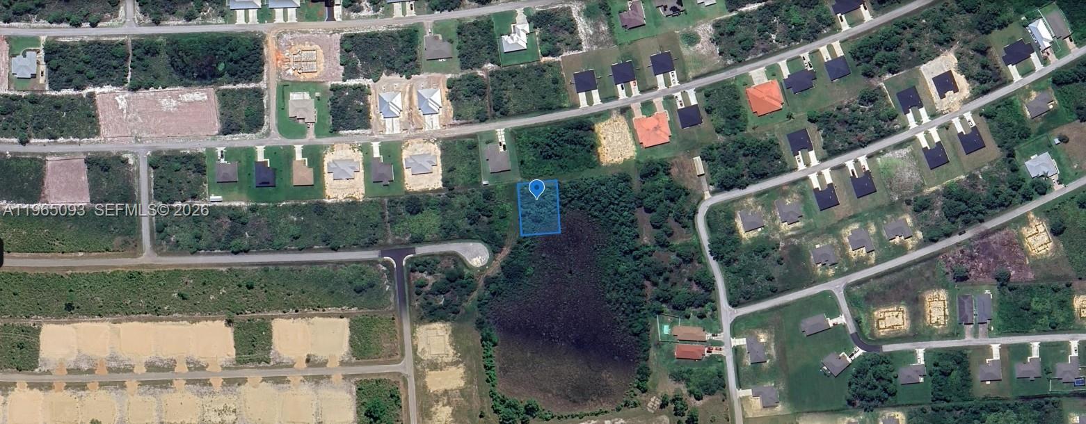 An aerial view shows a vacant residential lot highlighted in blue near a wooded area — 6857 Dickinson Drive, Sebring FL 33872, SEBRING, FL