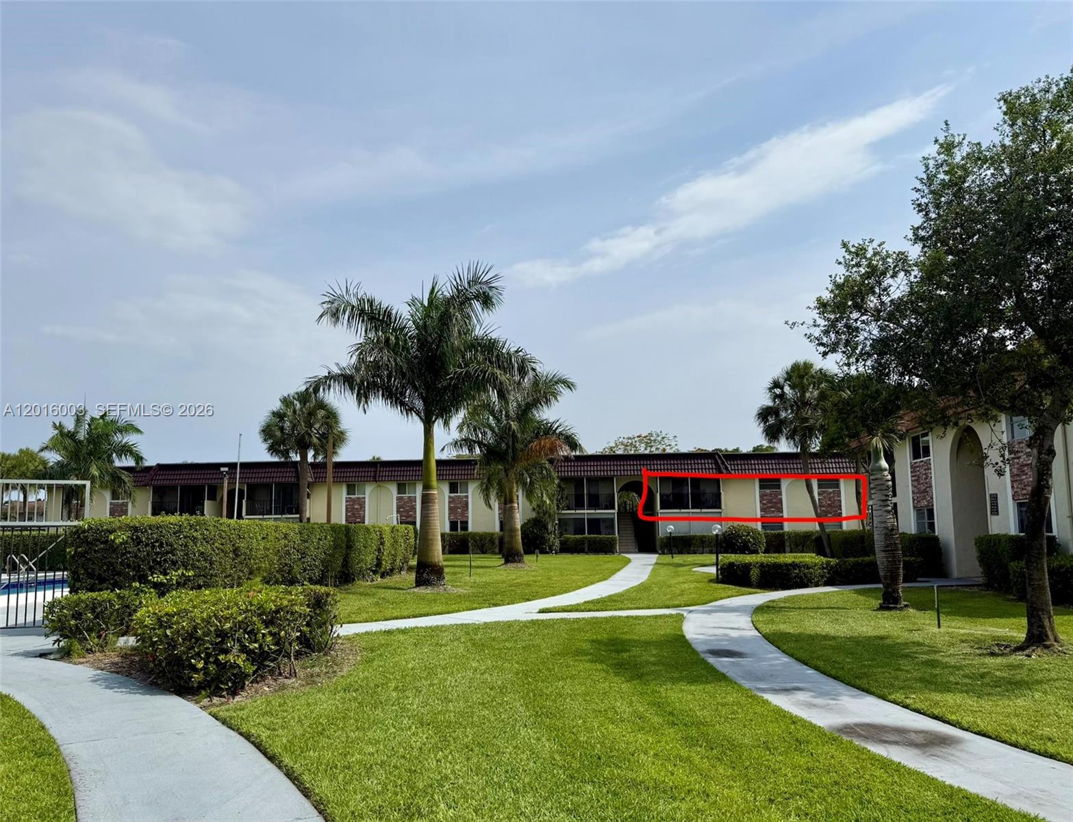 The exterior of a two-story apartment building features a red tiled roof and balconies — 22805 SW 66th Ave # 208, Boca Raton FL 33428, BOCA RATON, FL