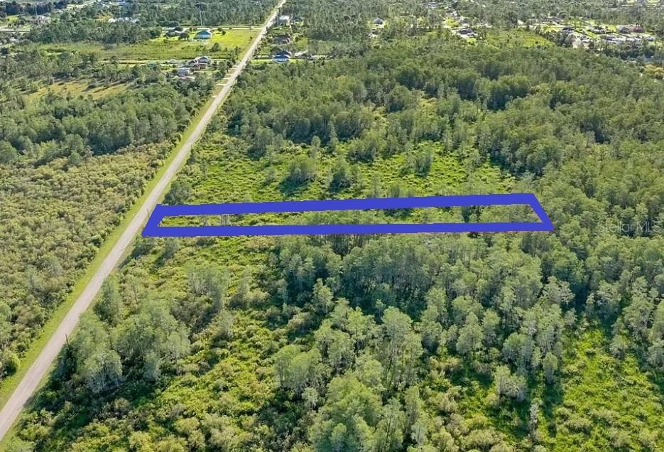 An aerial map view highlights a rectangular, undeveloped lot bordered by a road — 2630 NE 37TH AVENUE, NAPLES, FL