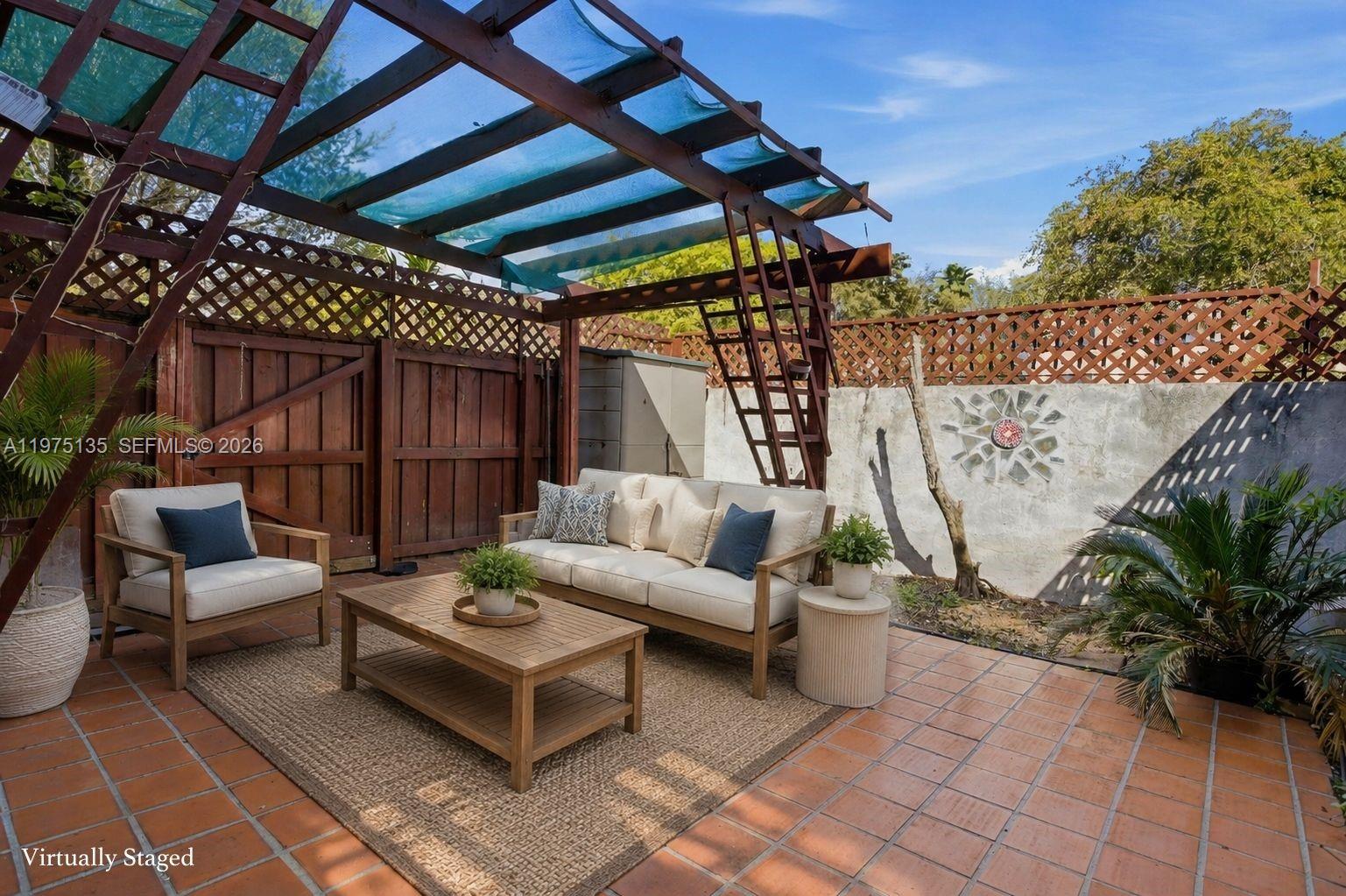 A patio features a wooden pergola, outdoor sofa, armchair, coffee table, and terracotta tile flooring — 12253 SW 16th Ter # M, Miami FL 33175, MIAMI, FL