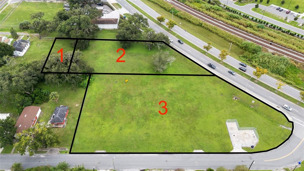 An aerial view shows three numbered plots of land adjacent to a road and railroad tracks — KATHLEEN ROAD, LAKELAND, FL