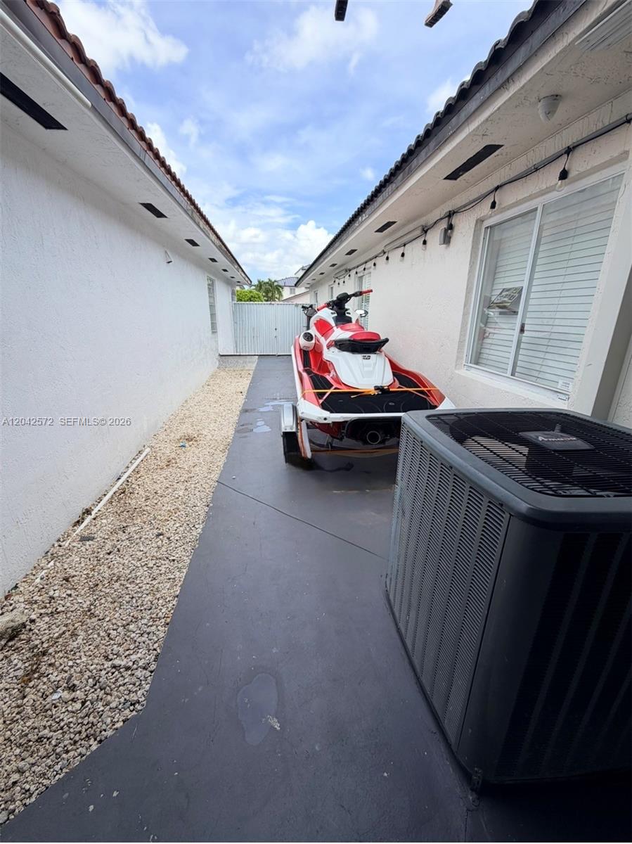A jet ski on a trailer sits in a narrow side yard between two buildings — 7898 W 34th Ct, Hialeah FL 33018, HIALEAH, FL