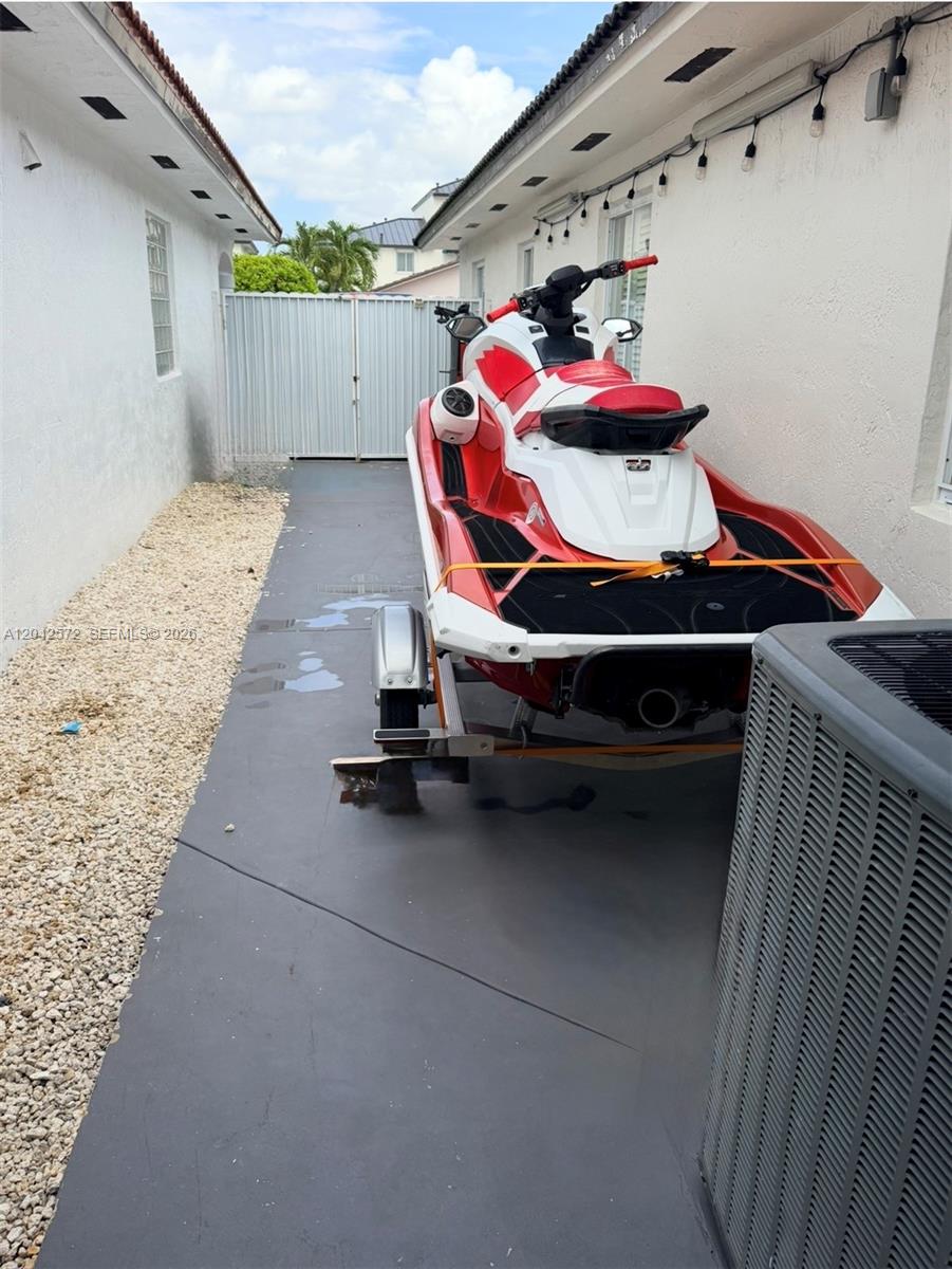 A red and white jet ski on a trailer is parked in a narrow side yard — 7898 W 34th Ct, Hialeah FL 33018, HIALEAH, FL