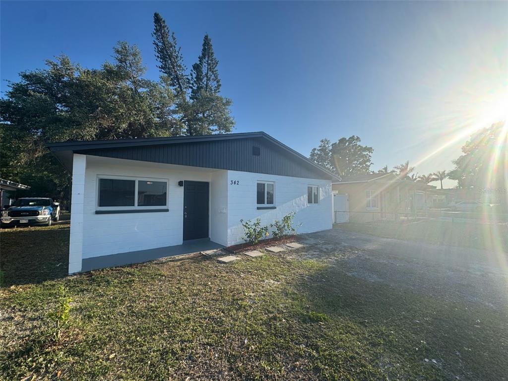 A single-story white house with a dark gray roof and trim sits on a lot — 342 51ST AVENUE N, ST PETERSBURG, FL