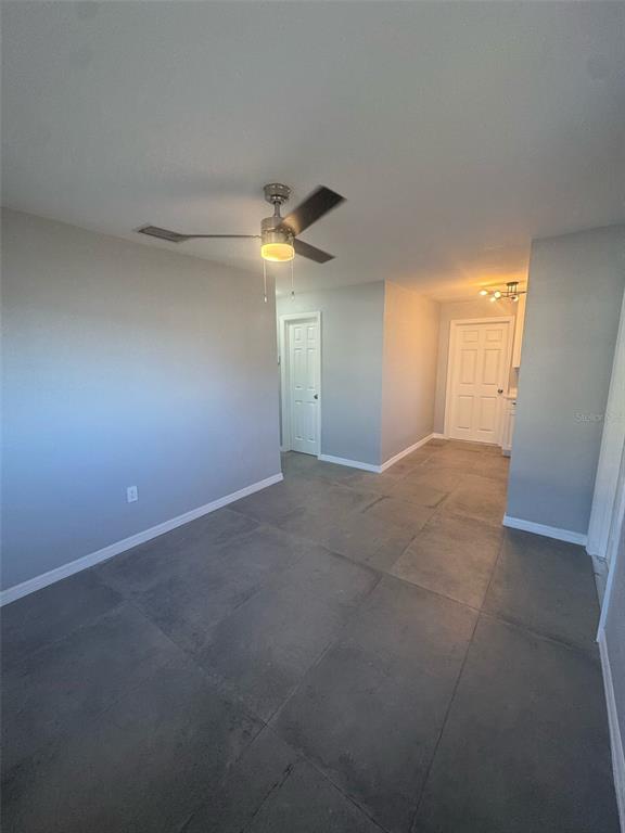 An interior room features gray walls, large square floor tiles, and a ceiling fan — 342 51ST AVENUE N, ST PETERSBURG, FL
