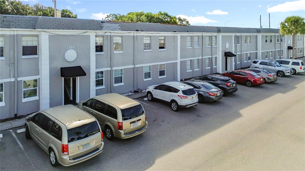 An exterior view of a multi-story apartment building with a parking lot in front — 2753 L B MCLEOD ROAD UNIT D, ORLANDO, FL