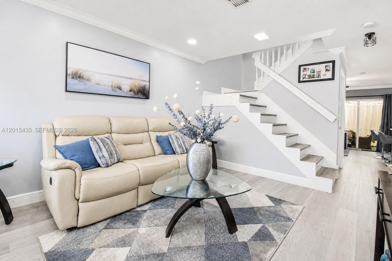 A living room features a beige leather sofa, a glass coffee table, and a staircase — 4946 SW 66th Ter, Davie FL 33314, DAVIE, FL