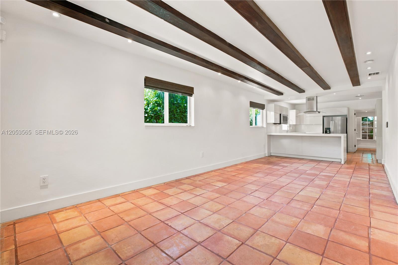 A room with terracotta tile flooring, white walls, and exposed dark wood ceiling beams — 3945 SW 61st Ave, Miami FL 33155, MIAMI, FL