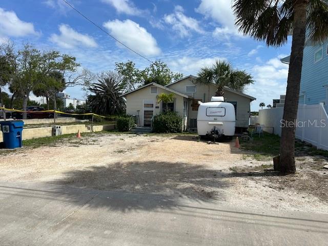 A small house with a white camper parked in the gravel front yard — 12620 LAGOON LANE, TREASURE ISLAND, FL