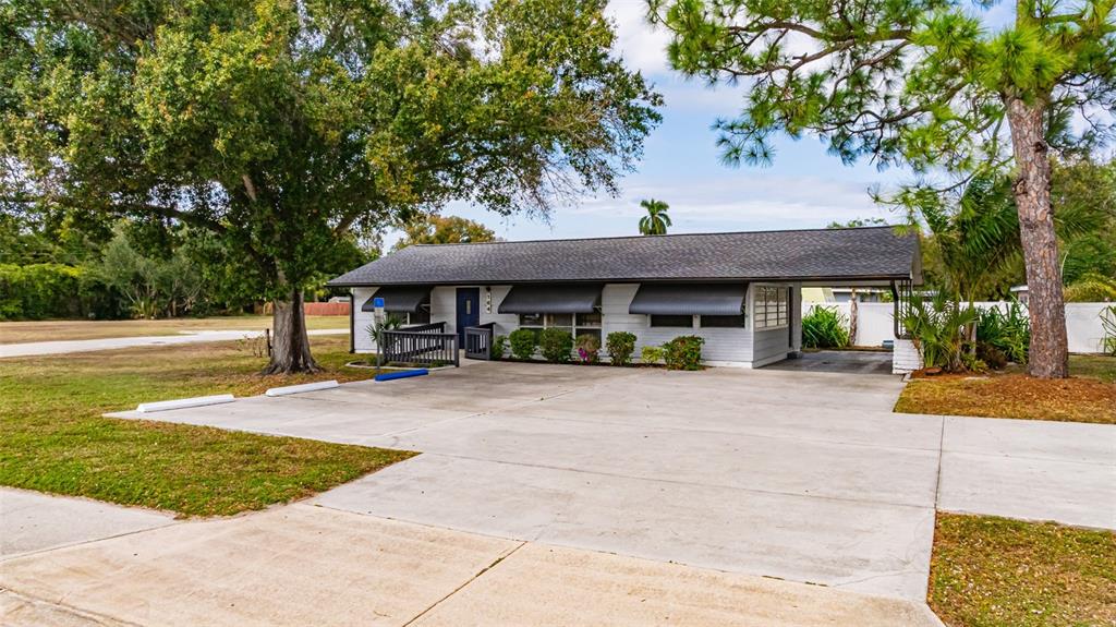 A single-story house with a carport, a wheelchair ramp, and a large concrete driveway — 164 PONDELLA ROAD, NORTH FORT MYERS, FL