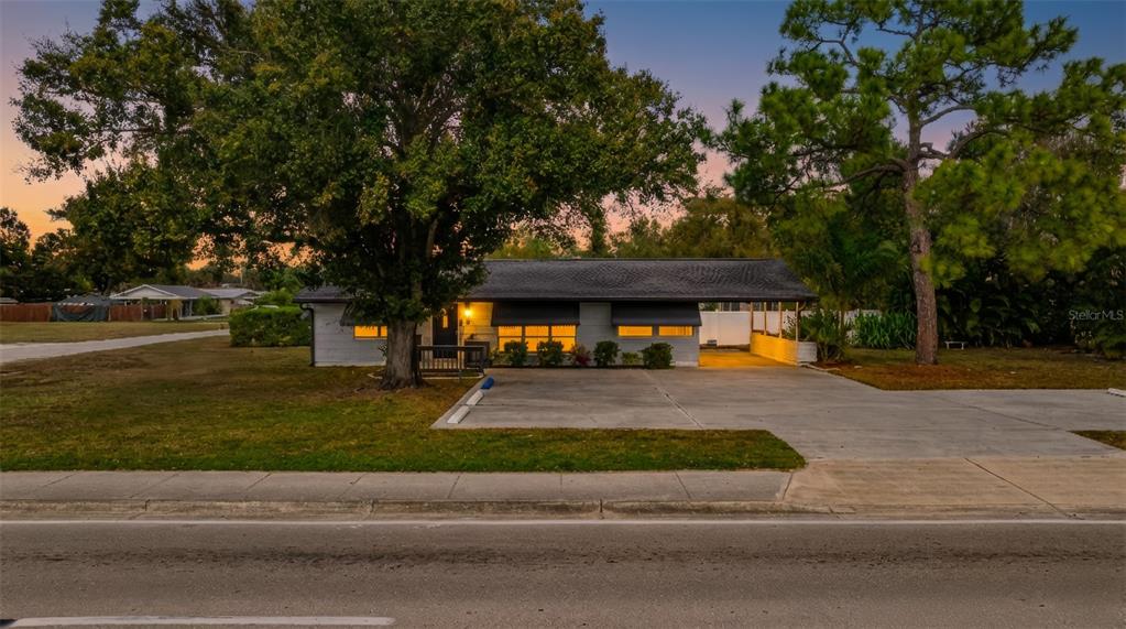 A single-story house with a carport and a large tree in the front yard — 164 PONDELLA ROAD, NORTH FORT MYERS, FL