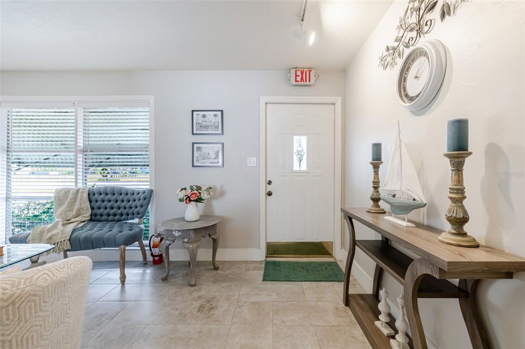 A bright entryway features tile flooring, a white front door, and a wooden console table — 164 PONDELLA ROAD, NORTH FORT MYERS, FL