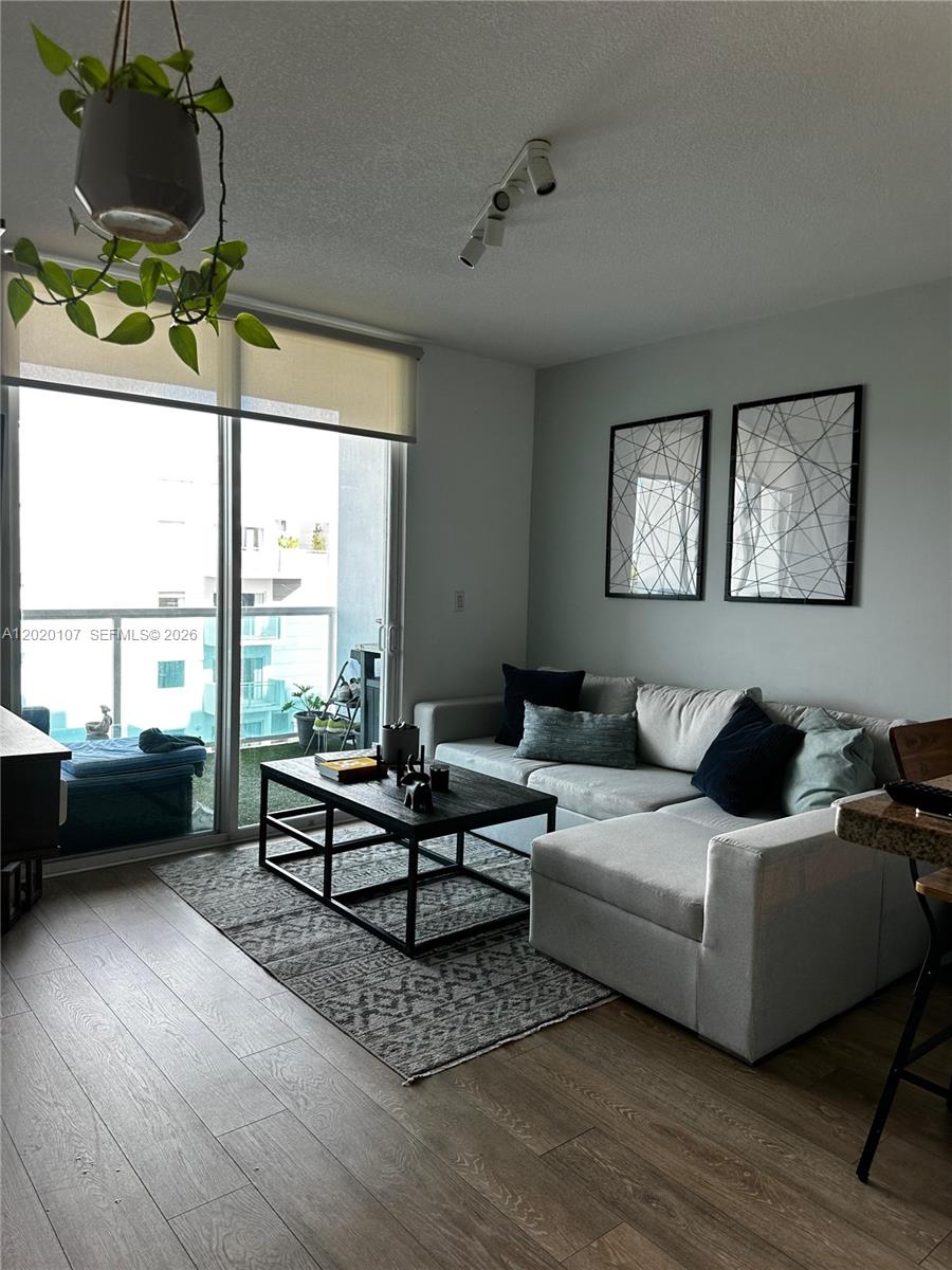 A living room features a sectional sofa, a coffee table, and a balcony with views — 1723 SW 2nd Ave # 704, Miami FL 33129, MIAMI, FL