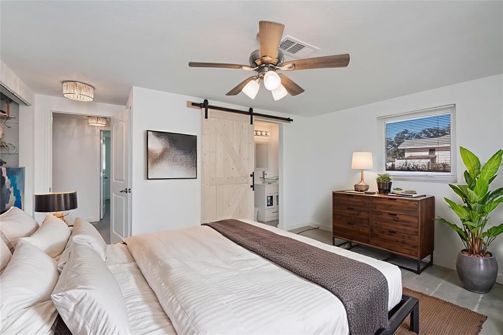 An open-concept living room features a fireplace, neutral furniture, and a kitchen in the background — 2820 MARLIN PLACE, PUNTA GORDA, FL