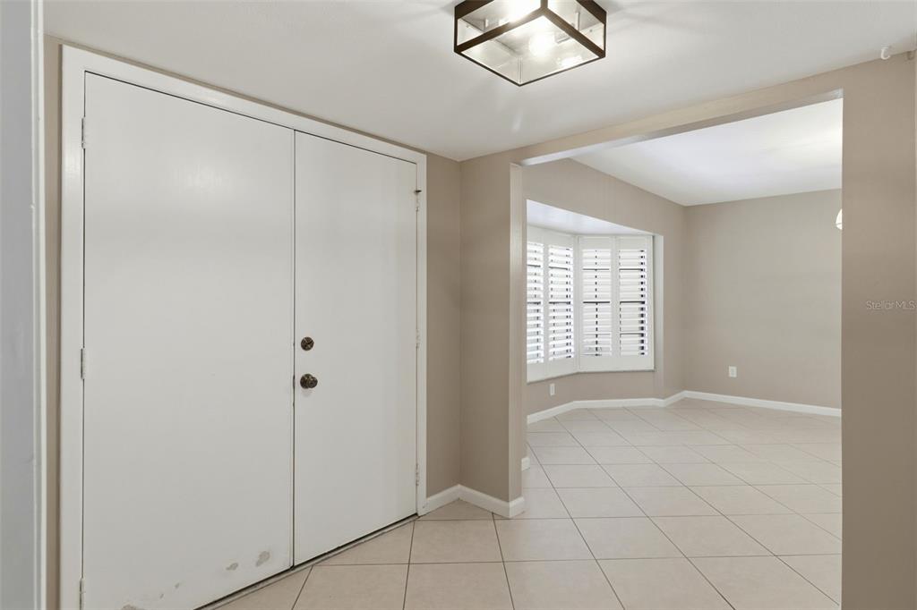 An entryway with white double doors, beige walls, and tiled floors leads into a room — 302 BLOOMINGFIELD DRIVE, BRANDON, FL