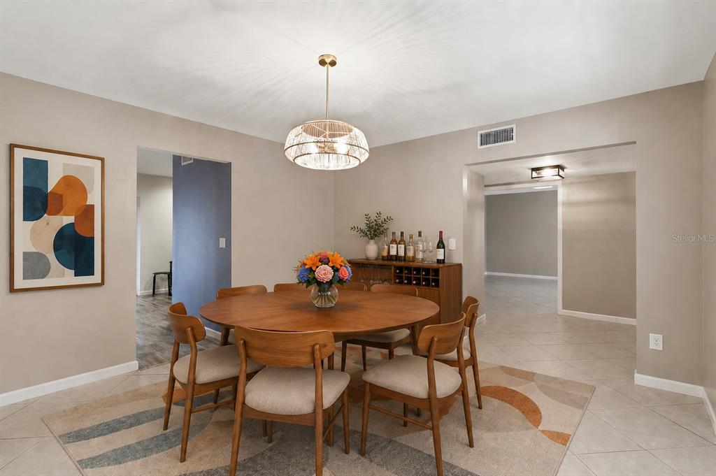 A dining room features a round wooden table, six chairs, and a modern pendant light — 302 BLOOMINGFIELD DRIVE, BRANDON, FL